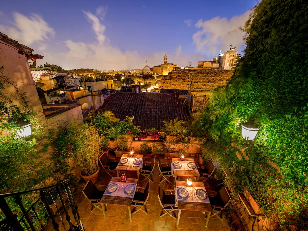 Rooftop dining terrace at The Inn at the Roman Forum overlooking Rome at dusk